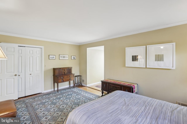 bedroom featuring baseboards, a closet, light wood-style flooring, and crown molding