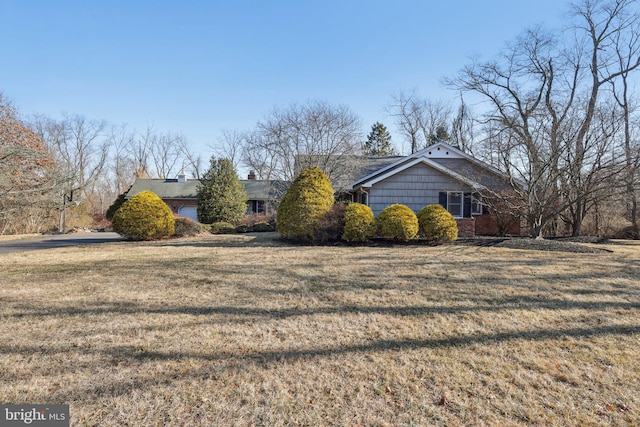 view of front of home with a front lawn and brick siding