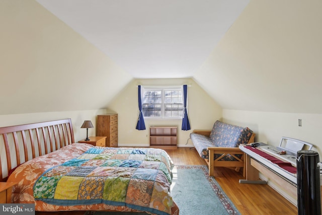 bedroom featuring lofted ceiling and wood finished floors