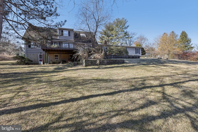 back of property with a yard and a wooden deck