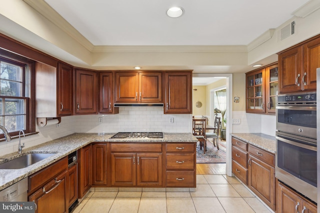 kitchen with stainless steel appliances, a healthy amount of sunlight, a sink, and under cabinet range hood