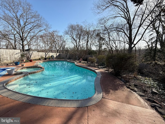 view of pool featuring a patio, a pool with connected hot tub, and a fenced backyard