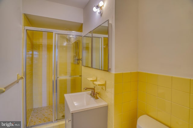 bathroom featuring tile walls, vanity, toilet, and walk in shower