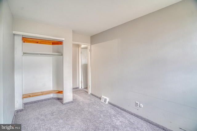 unfurnished bedroom featuring a closet and light colored carpet