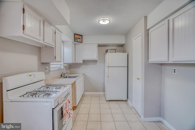 kitchen featuring white appliances, a textured ceiling, white cabinets, light tile patterned floors, and sink