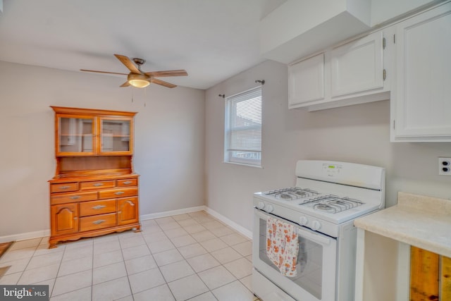 kitchen featuring white cabinetry, white range with gas cooktop, ceiling fan, and light tile patterned floors