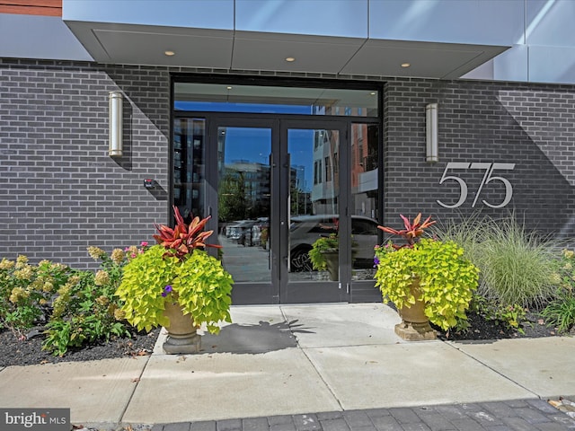 doorway to property featuring brick siding and french doors