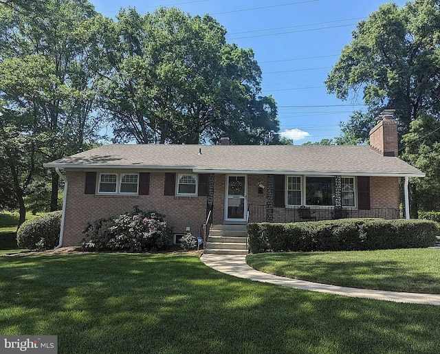 ranch-style home with a chimney, a front lawn, a porch, and brick siding