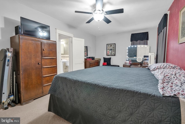 bedroom with ensuite bath, a ceiling fan, and light colored carpet