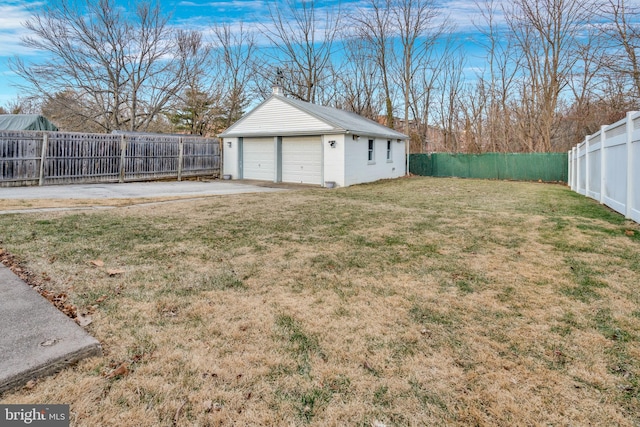 view of yard featuring a garage, an outbuilding, and a fenced backyard