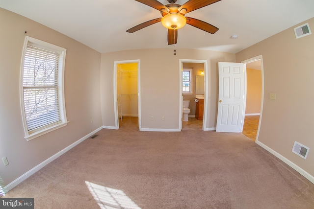 unfurnished bedroom featuring visible vents, a walk in closet, and baseboards