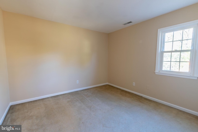 carpeted empty room with visible vents and baseboards