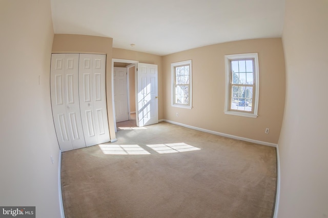 unfurnished bedroom with a closet, baseboards, and carpet