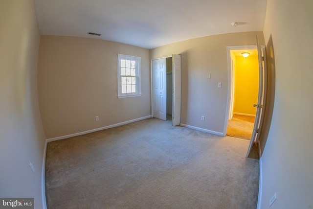 unfurnished bedroom featuring visible vents, baseboards, carpet, and a closet