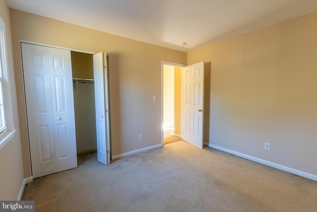 unfurnished bedroom with a closet, baseboards, and carpet