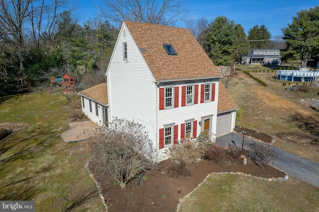 exterior space with aphalt driveway and roof with shingles