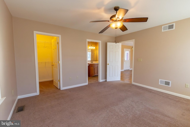 unfurnished bedroom with visible vents, carpet, and a spacious closet