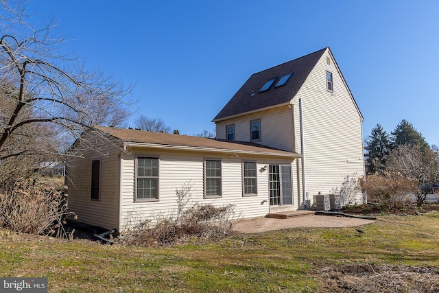 rear view of house with a lawn, central AC unit, and a patio area