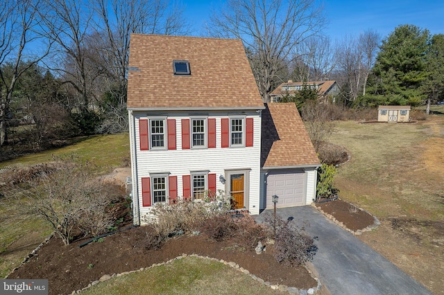 view of front of house with aphalt driveway, a garage, and a shingled roof