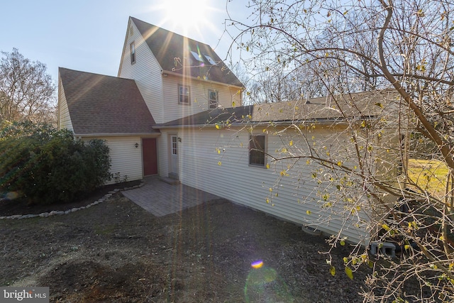 view of front of property featuring a patio area and a shingled roof