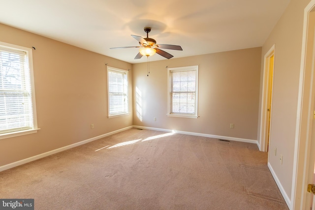 unfurnished room featuring light colored carpet, baseboards, and ceiling fan