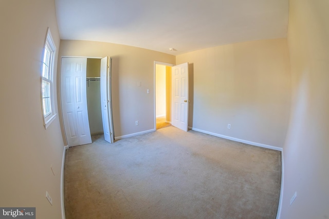 unfurnished bedroom featuring a closet, carpet flooring, and baseboards