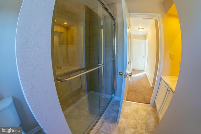 bathroom featuring a stall shower, toilet, and vanity