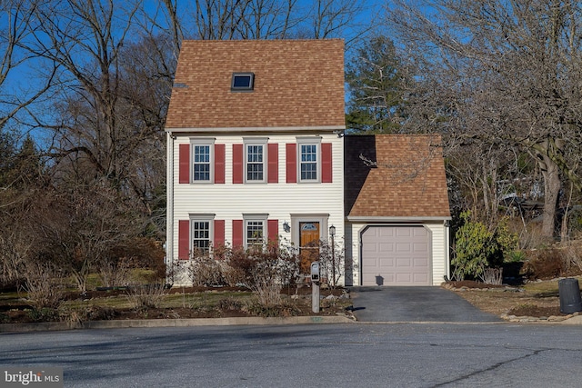 view of front of home featuring aphalt driveway, a garage, and roof with shingles