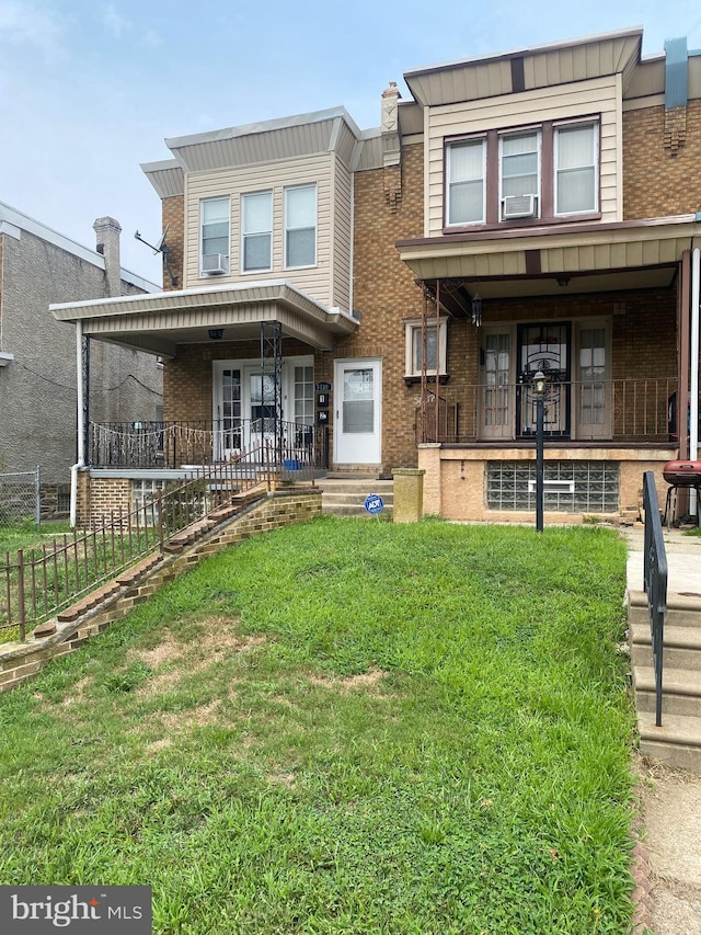 view of property with a porch and a front lawn