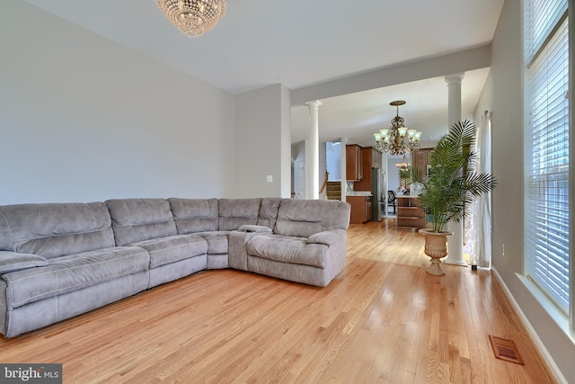 5816 Rockburn Woods Way, Elkridge, MD 21075 - living room with light wood-type flooring, ornate columns, and a notable chandelier