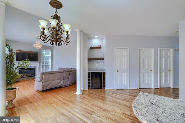 5816 Rockburn Woods Way, Elkridge, MD 21075 - living room featuring bar, ornate columns, a chandelier, and wood-type flooring