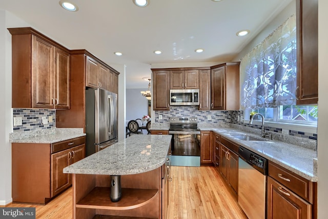 5816 Rockburn Woods Way, Elkridge, MD 21075 - kitchen featuring stainless steel appliances, light stone counters, light hardwood / wood-style floors, a kitchen island, and sink