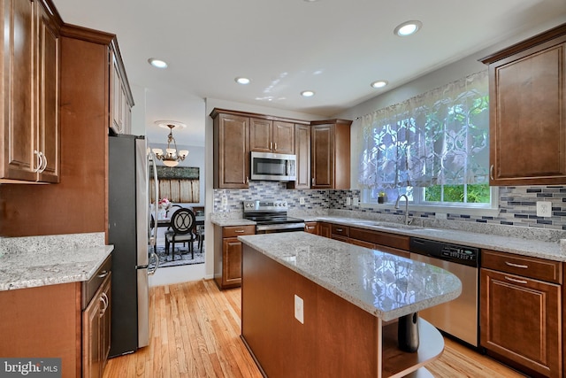 5816 Rockburn Woods Way, Elkridge, MD 21075 - kitchen featuring light hardwood / wood-style flooring, appliances with stainless steel finishes, sink, a kitchen island, and light stone countertops