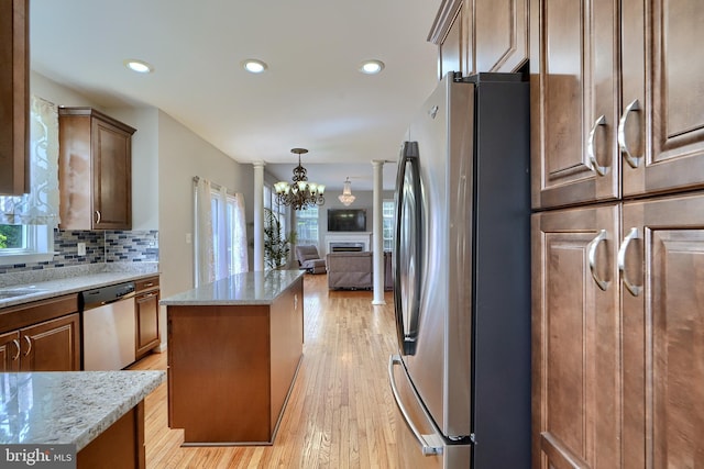 5816 Rockburn Woods Way, Elkridge, MD 21075 - kitchen featuring appliances with stainless steel finishes, a chandelier, light stone counters, a kitchen island, and tasteful backsplash