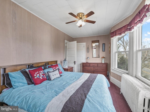 bedroom featuring radiator, ceiling fan, and dark colored carpet