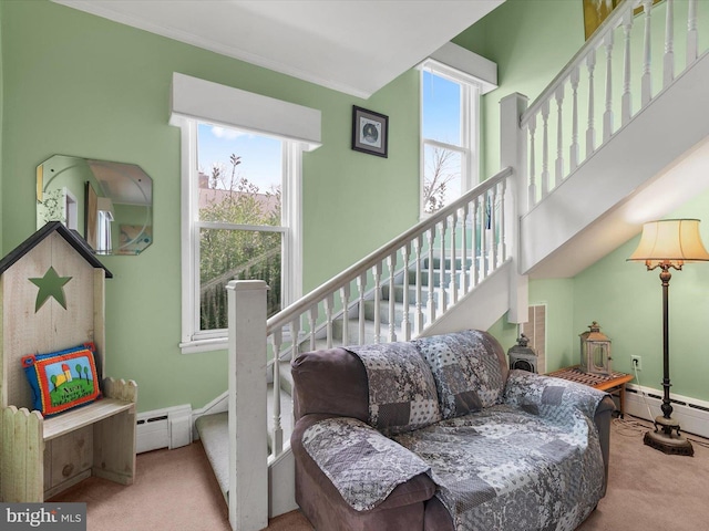 living room with light carpet, a healthy amount of sunlight, and baseboard heating