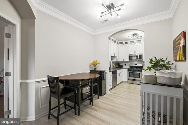 kitchen featuring stainless steel appliances, visible vents, white cabinetry, dark countertops, and glass insert cabinets