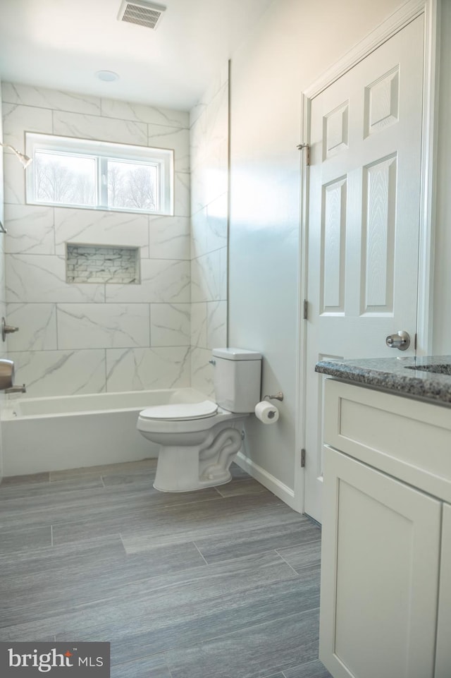 bathroom with shower / bath combination, visible vents, toilet, wood tiled floor, and vanity