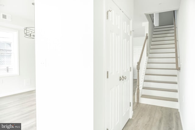 staircase with visible vents, baseboards, and wood finished floors