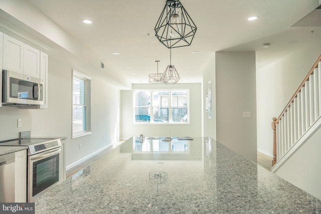 kitchen with light stone counters, stainless steel appliances, a wealth of natural light, and recessed lighting