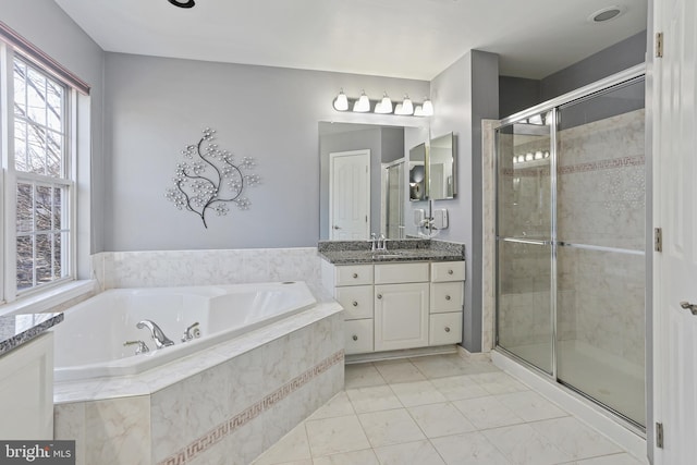 bathroom with a stall shower, tile patterned floors, a garden tub, and vanity