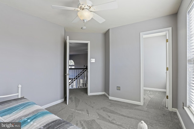 bedroom featuring light colored carpet, ceiling fan, and baseboards