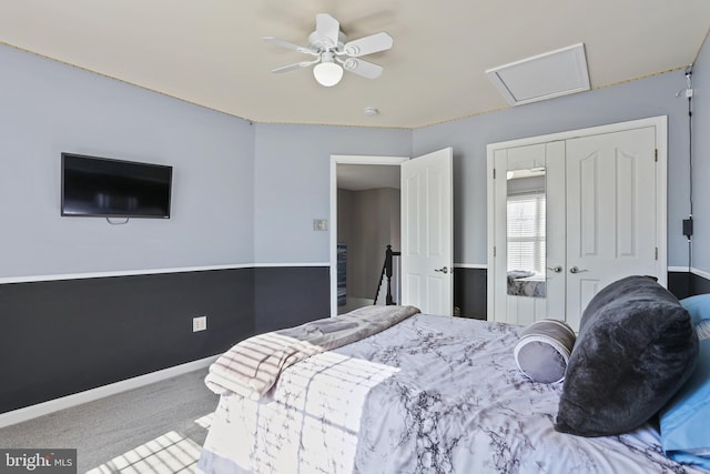 carpeted bedroom with attic access, a closet, baseboards, and a ceiling fan