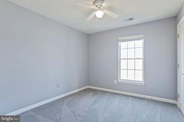 carpeted empty room with a ceiling fan, visible vents, and baseboards