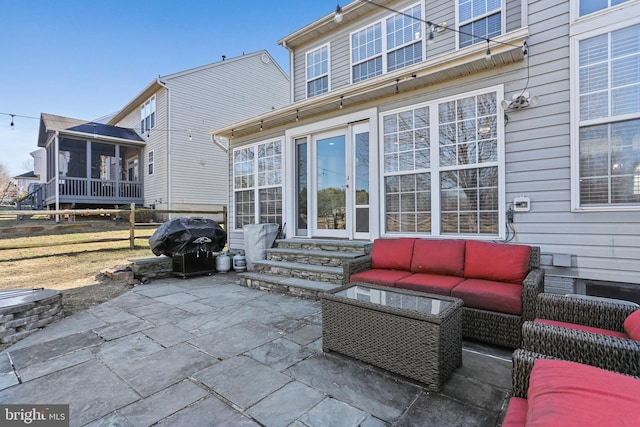 view of patio / terrace with entry steps, a sunroom, an outdoor living space, and grilling area