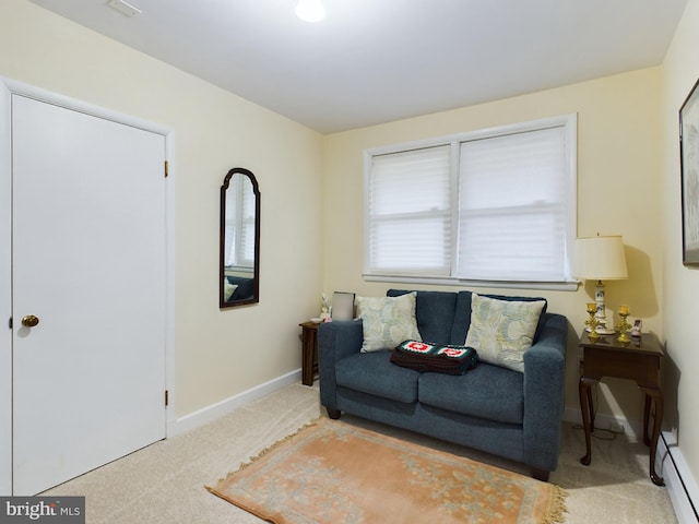 sitting room featuring a baseboard heating unit and light colored carpet