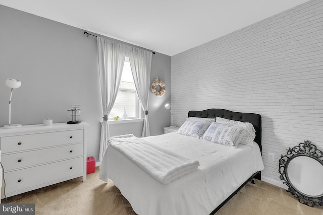 bedroom featuring light carpet and brick wall