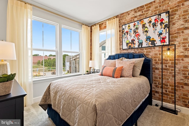 bedroom featuring brick wall, multiple windows, and light colored carpet