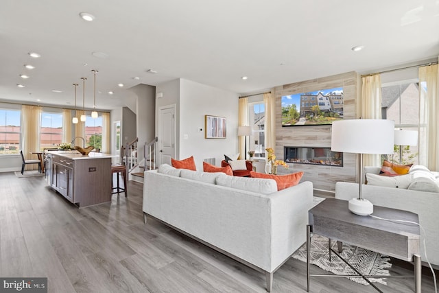 living room with a tiled fireplace and hardwood / wood-style floors