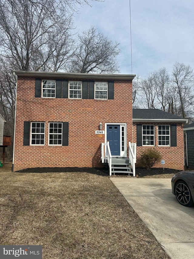 view of front of home featuring brick siding and a front lawn